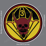 Circular logo featuring a red horned skull with a mustache inside a yellow and black ring, with two crossed yellow shapes behind and the number 3 on a helmet at the top of the design.