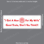 White bumper sticker on a gray background with red text: "I Got A New VW For My Wife" and the VW logo, followed by "Good Trade, Don't You Think!!!"